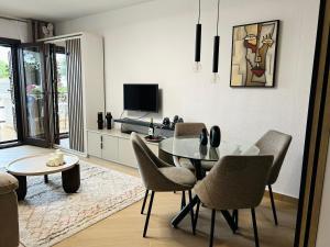 un salon avec une table, des chaises et une télévision dans l'établissement Casa Refa en Cabo Roig, à Orihuela Costa