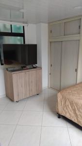 um quarto com uma televisão de ecrã plano num armário de madeira em HABITACIÓN PRIVADA tranquila y confortable em Bello