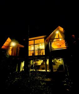 a house lit up at night with lights at Cabana Suspensa na Natureza - Região Turística in Campos do Jordão