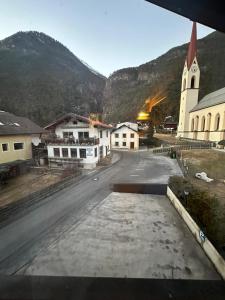 uma rua vazia numa cidade com uma igreja em Dorfwirt em Mils bei Imst