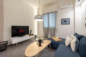 sala de estar con sofá azul y TV en Ports Crossroad C, en Pireo