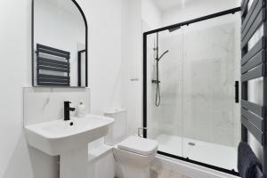 a white bathroom with a sink and a shower at Apt 1, 15 West Street in Hereford +8 photos