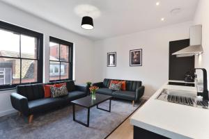 a living room with two couches and a table at Apt 1, 15 West Street in Hereford