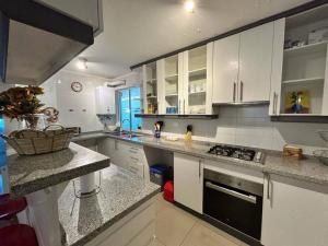 a kitchen with white cabinets and a black stove top oven at Hermoso Depto. Santo Domingo in Santo Domingo