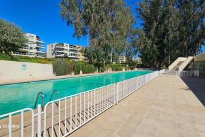 a swimming pool with a fence next to the water at Hermoso Depto. Santo Domingo in Santo Domingo