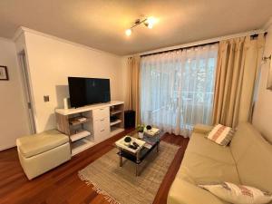 a living room with a couch and a flat screen tv at Hermoso Depto. Santo Domingo in Santo Domingo