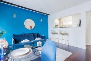 ein blaues Wohnzimmer mit einem blauen Sofa und einem Glastisch in der Unterkunft Charming 4P apartment Saint Mande in Saint-Mandé