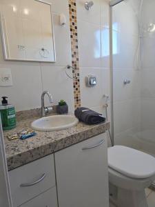 a bathroom with a sink and a toilet and a shower at Hospedagem Flat verde Sul de Minas in Caxambu +11 photos