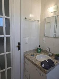 a bathroom with a sink and a mirror at Hospedagem Flat verde Sul de Minas in Caxambu