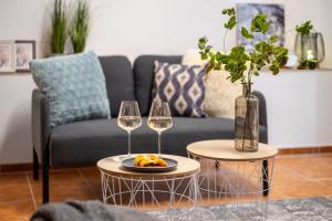 a living room with two wine glasses and a couch at New flat, Jachymov (Klinovec resort) in Karlovy Vary