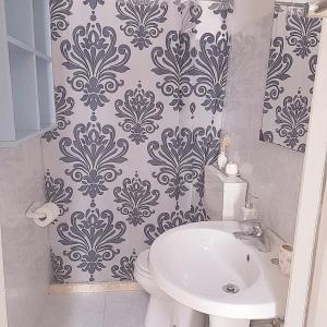 a bathroom with a white toilet and a sink at Serrano relax room in Serrano +25 photos