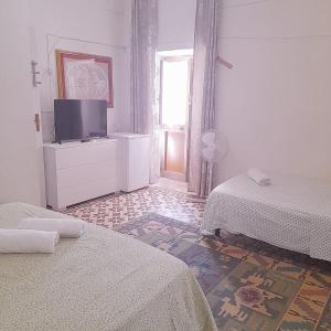 Habitación blanca con 2 camas y TV en Serrano relax room, en Serrano