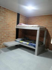 Cette chambre dispose de lits superposés et d'un mur en briques. dans l'établissement Cabaña la isla, à Coveñas