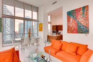sala de estar con sofá naranja y mesa en Stunning Brickell Luxury Condo en Miami