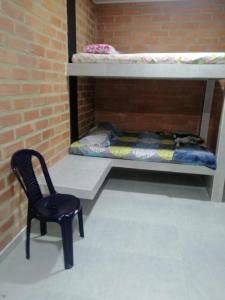 une chaise dans une chambre avec des lits superposés dans l'établissement Cabaña la isla, à Coveñas
