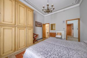 Un dormitorio con una cama grande y una lámpara de araña. en Da Leonardo Apartment, en Florencia