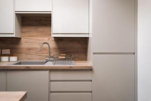 una cocina con armarios blancos y fregadero en Contractor Base Sleeps 7, Pool Table & PS4, en Gillingham