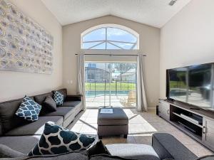 ein Wohnzimmer mit einem Sofa und einem Flachbild-TV in der Unterkunft 5 Star Home* Private Pool & Jaccuzzi*Free Wi-Fi* in Kissimmee