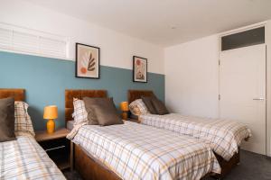 Duas camas num quarto com paredes azuis em Contractor Base Sleeps 7, Pool Table & PS4 em Gillingham