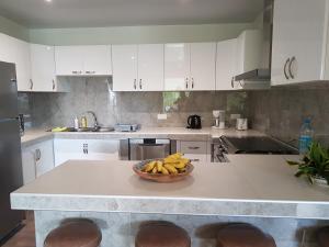 a kitchen with a bowl of bananas on a counter at Villas TEAKEVEHERE - Fare OPUHI in Pirae