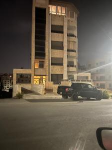 安曼的住宿－1BR-Deir Gbar rooftop，停在大楼前的一辆黑色卡车
