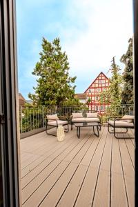 una terraza de madera con bancos y una mesa. en Himmlische Altstadt-Maisonette, en Marburg an der Lahn