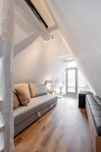 una sala de estar con sofá en un loft en Himmlische Altstadt-Maisonette, en Marburg an der Lahn