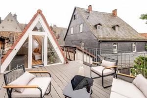 una casa con balcón y muebles blancos. en Himmlische Altstadt-Maisonette en Marburg an der Lahn