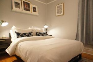 a bedroom with a large white bed with two lights at Cozy Nest in Chicago's Vibrant Lincoln Square in Chicago
