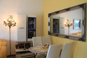 a dining room with a table and a mirror at Casa Roccia in Pino Lago Maggiore