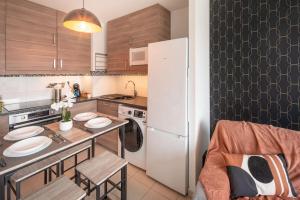 a kitchen with a table and a white refrigerator at L'excellence-8min Aéroport-terrasse-Parking Privé in Lingolsheim +7 photos