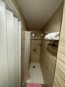 a small bathroom with a shower and a bed at Alojamiento Canaima in Málaga