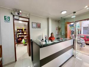 a woman sitting at a counter in a store at La Villa de Roel in Ayacucho