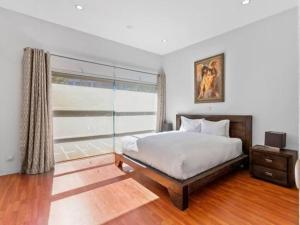 um quarto com uma cama grande e uma janela em Sleek Modern Pad next to Spark Arena Free Parking em Auckland