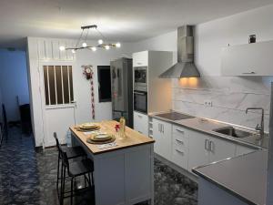 a kitchen with white cabinets and a kitchen island with chairs at Edificio Juan Ávila cabrera in Gran Tarajal +5 photos