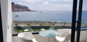 a view of the ocean from a room with a table and chairs at Cura Marina Premium in Mogán