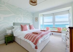 a bedroom with a bed with a view of the ocean at Lundy House in Port Isaac