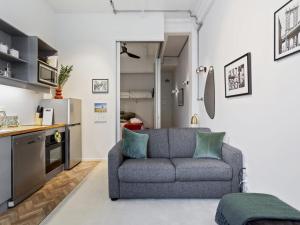 sala de estar con sofá y cocina en Cosy Central Apartment - Charming Building en Auckland