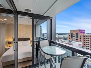 a balcony with a bed and a table and chairs at Stunning Apartment Amazing View near Sky Tower in Auckland