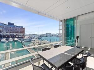 a balcony with a table and chairs and a harbor at Gorgeous 2BR in Wynyard Quarter by Zodiak Stays in Auckland