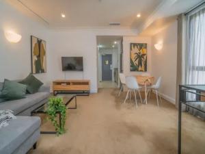 オークランドにあるSpacious 1BR Apt Parking, Gym ,Pool by Zodiak Staysのソファとテーブルのあるリビングルーム