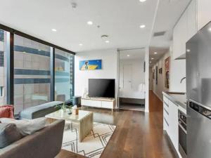 a living room with a couch and a tv at Two bedroom apartment - large balcony central in Auckland