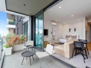 um quarto com uma cama e uma sala de estar em Sleek Modern Studio with Balcony em Auckland