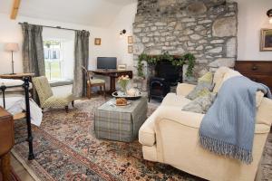a living room with a couch and a stone fireplace at Pigeon Loft in Kirk Yetholm