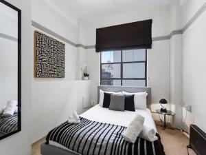 a bedroom with a bed with a black and white comforter at Lovely 1-Bedroom Unit in Central Auckland in Auckland