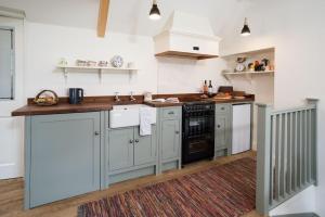 a kitchen with gray cabinets and black appliances at Pigeon Loft in Kirk Yetholm