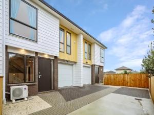 uma casa com uma fachada branca e amarela em Stunning Three Bedroom Townhouse with Free Parking em Auckland