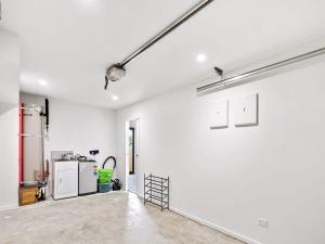 Habitación vacía con paredes blancas y cocina. en Gorgeous Three Bedroom Home with Free Parking, en Auckland
