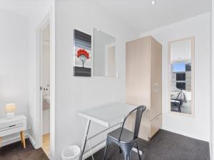 a white room with a table and a chair at Central City 1BR Apartment in Auckland