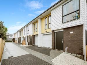 a row of apartment buildings with garages at Gorgeous Three Bedroom Home with Free Parking in Auckland